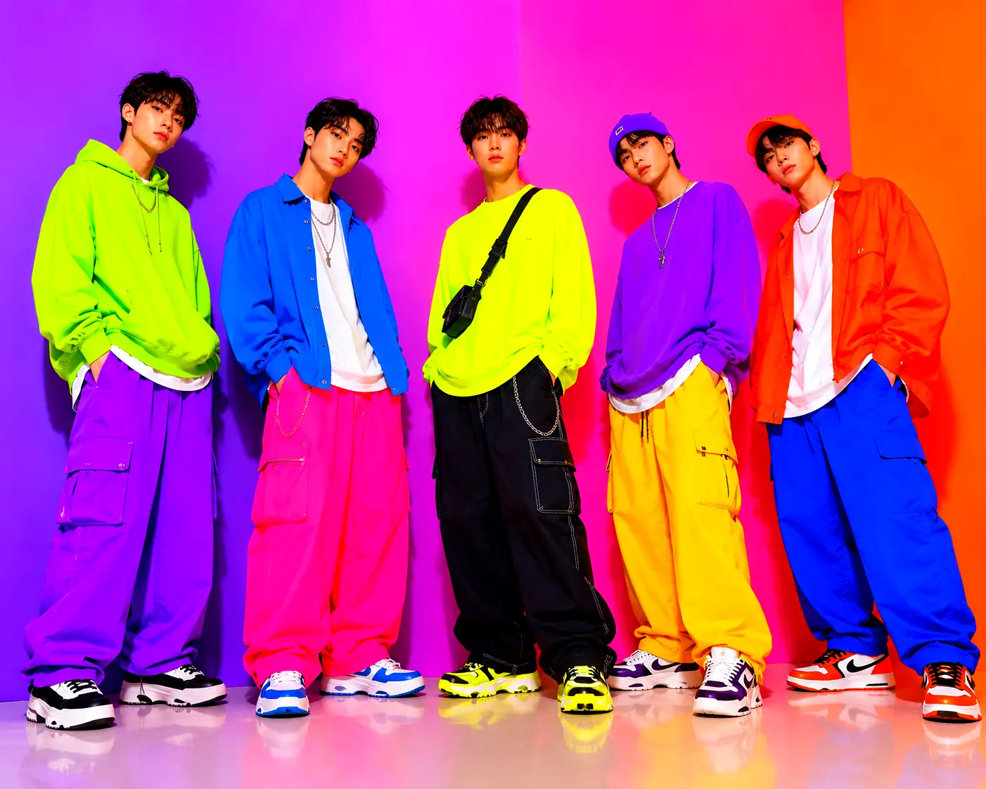 Groupe d’hommes en tenue streetwear coréenne oversize avec couleurs néon flashy sur fond violet, rose et orange vif